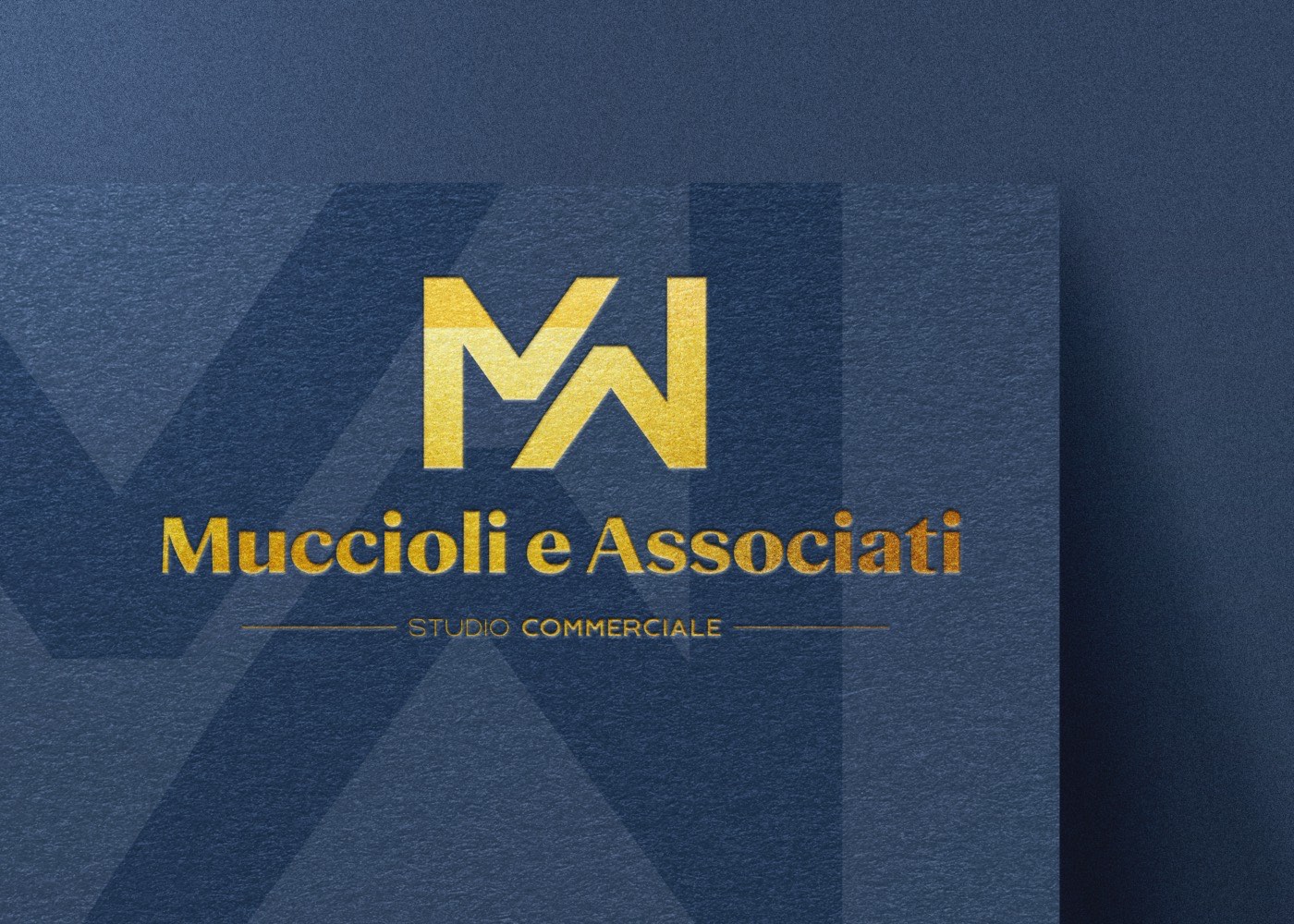 Il marchio di Muccioli e Associati, monogramma in foglia oro su carta blu, disegnato da Miketing